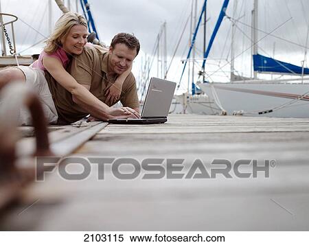 Couple using laptop at harbor View Large Photo Image Stock Photography - Couple using laptop at harbor . Fotosearch