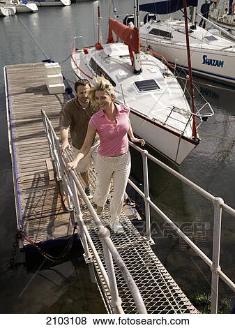 Couple walking on platform at harbor View Large Photo Image Stock Photo - Couple walking on platform at harbor . Fotosearch