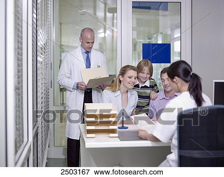 Stock Photo - Couple with their son discussing with female doctor . Fotosearch