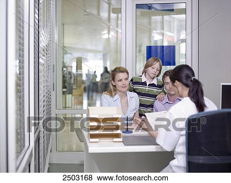 Couple with their son discussing with female doctor View Large Photo Image Stock Photo - Couple with their son discussing with female doctor . Fotosearch