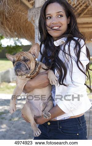 Dark-haired woman holding pug View Large Photo Image Stock Image - Dark-haired woman holding pug . Fotosearch