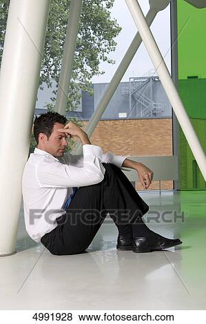 Stock Photo - Depressed businessman sitting on floor . Fotosearch