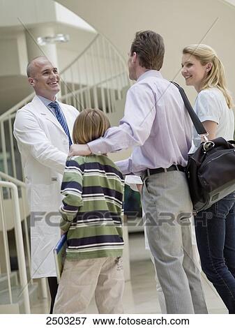 Stock Photo - Doctor discussing with patients in hospital . Fotosearch