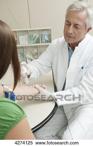 Doctor disinfecting patient's arm View Large Photo Image Stock Photography - Doctor disinfecting patient's arm . Fotosearch