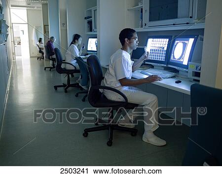 Stock Image - Doctor examining medical report on computer . Fotosearch