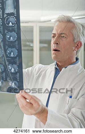 Doctor looking at x-ray View Large Photo Image Stock Image - Doctor looking at x-ray . Fotosearch