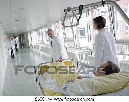 Doctor pulling patient on gurney View Large Photo Image Picture - Doctor pulling patient on gurney . Fotosearch