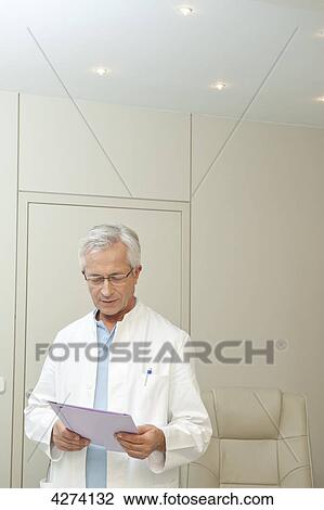 Doctor reading document View Large Photo Image Stock Image - Doctor reading document . Fotosearch
