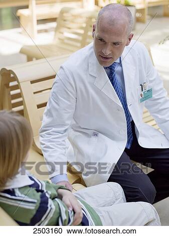 Stock Image - Doctor sitting with patient on bench . Fotosearch