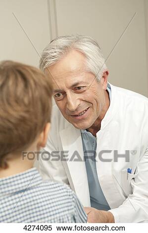 Doctor smiling at boy View Large Photo Image Stock Photography - Doctor smiling at boy . Fotosearch