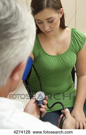 Doctor taking patient's blood pressure View Large Photo Image Stock Photo - Doctor taking patient's blood pressure . Fotosearch