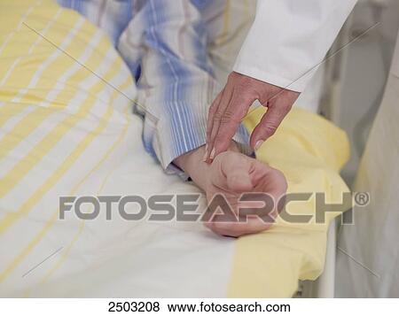 Doctor taking pulse of patient View Large Photo Image Stock Photo - Doctor taking pulse of patient . Fotosearch