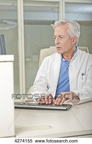 Doctor using computer at desk View Large Photo Image Stock Photography - Doctor using computer at desk . Fotosearch