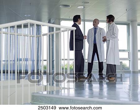 Doctors discussing with businessman in hospital View Large Photo Image Stock Photo - Doctors discussing with businessman in hospital . Fotosearch