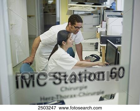 Stock Photo - Doctors examining medical report on computer . Fotosearch