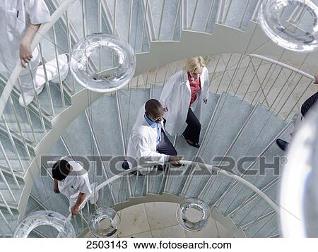 Doctors moving on spiral staircase View Large Photo Image Stock Image - Doctors moving on spiral staircase . Fotosearch