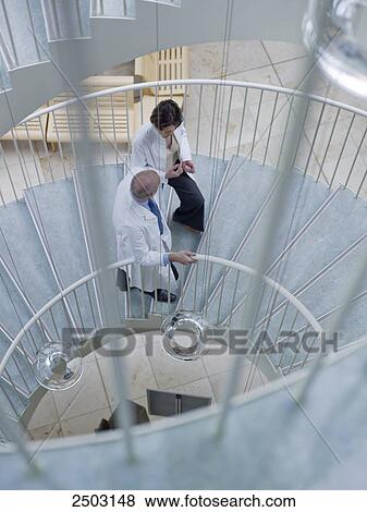 Doctors moving up on spiral staircase View Large Photo Image Stock Photo - Doctors moving up on spiral staircase . Fotosearch