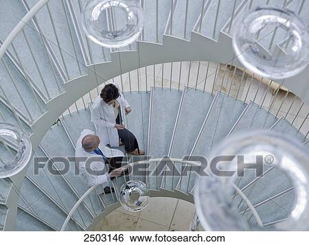 Stock Photograph - Doctors moving up on spiral staircase . Fotosearch