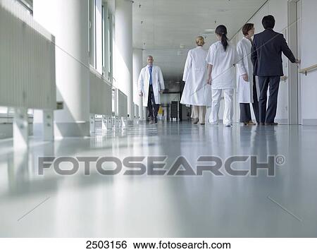 Stock Photograph - Doctors walking in corridor of hospital . Fotosearch