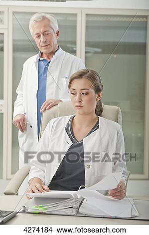 Picture - Doubtful doctor and doctor's assistant in medical practice . Fotosearch