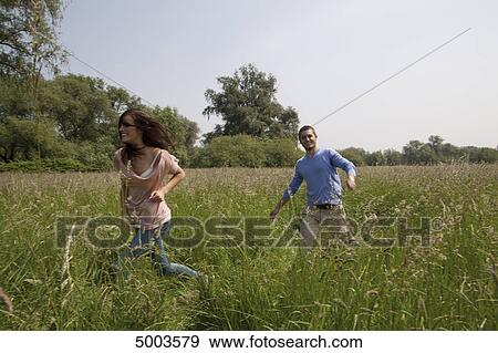 Enthusiastic young couple in field View Large Photo Image Stock Photo - Enthusiastic young couple in field . Fotosearch