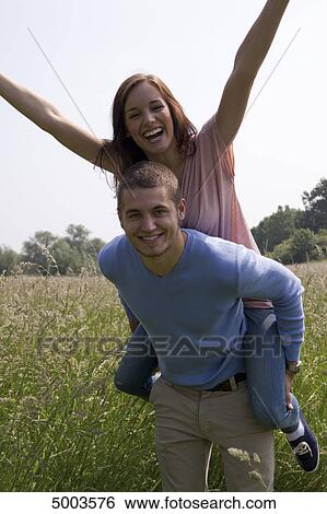 Enthusiastic young couple in field View Large Photo Image Stock Photograph - Enthusiastic young couple in field . Fotosearch