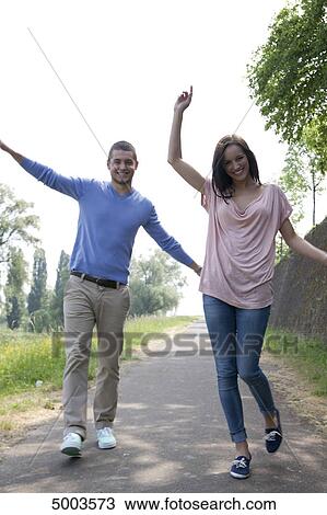 Stock Image - Enthusiastic young couple on a path . Fotosearch