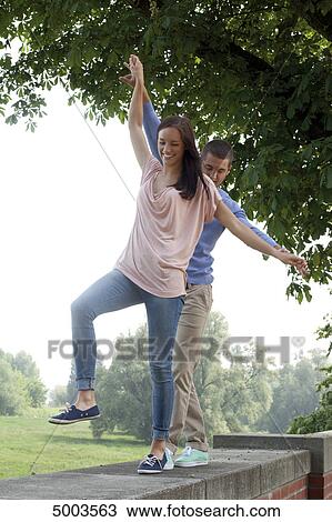 Enthusiastic young couple on a wall View Large Photo Image Stock Image - Enthusiastic young couple on a wall . Fotosearch