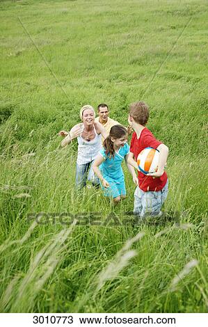 Stock Image - Familiy playing in meadow, high angle view . Fotosearch