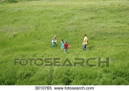 Familiy playing in meadow, high angle view View Large Photo Image Stock Photography - Familiy playing in meadow, high angle view . Fotosearch