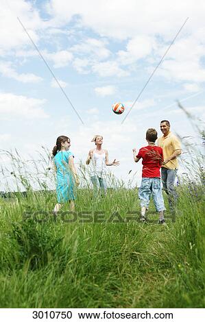 Stock Image - Familiy playing in meadow, low angle view . Fotosearch