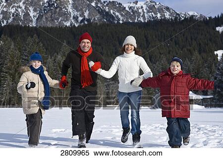 Stock Photography - Family enjoying in snow covering landscape . Fotosearch