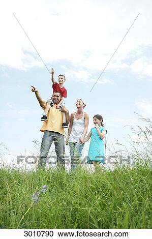 Family on a meadow, low angle view View Large Photo Image Stock Image - Family on a meadow, low angle view . Fotosearch