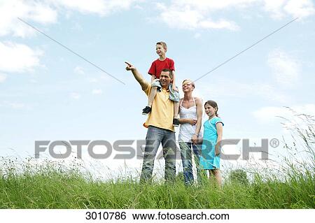 Stock Photograph - Family on a meadow, low angle view . Fotosearch