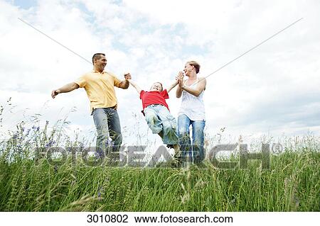 Stock Image - Family playing on a meadow, low angle view . Fotosearch