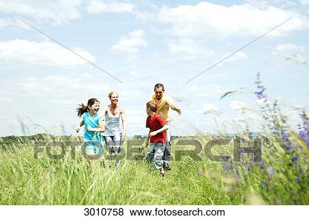 Family playing on a meadow, low angle view View Large Photo Image Stock Photo - Family playing on a meadow, low angle view . Fotosearch