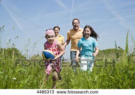 Family running over a meadow View Large Photo Image Stock Image - Family running over a meadow . Fotosearch