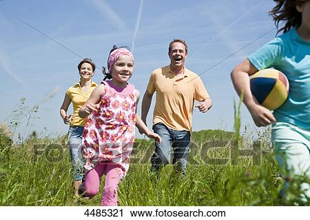 Family running over a meadow View Large Photo Image Stock Image - Family running over a meadow . Fotosearch