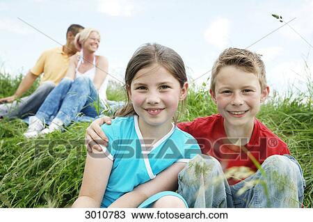Family sitting on grass View Large Photo Image Stock Image - Family sitting on grass . Fotosearch