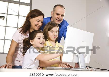 Family smiling while watching on computer screen View Large Photo Image Stock Image - Family smiling while watching on computer screen . Fotosearch