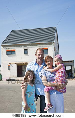 Family standing in front of shell of building View Large Photo Image Stock Photo - Family standing in front of shell of building . Fotosearch
