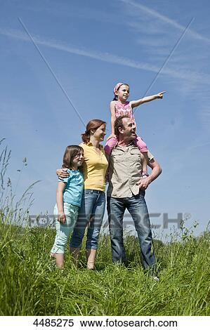 Stock Photography - Family standing on a meadow . Fotosearch