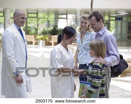 Family standing with doctors in hospital View Large Photo Image Stock Image - Family standing with doctors in hospital . Fotosearch