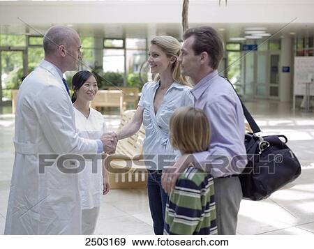 Family standing with doctors in hospital View Large Photo Image Stock Photo - Family standing with doctors in hospital . Fotosearch
