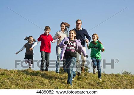 Family with four kids running over meadow View Large Photo Image Stock Image - Family with four kids running over meadow . Fotosearch