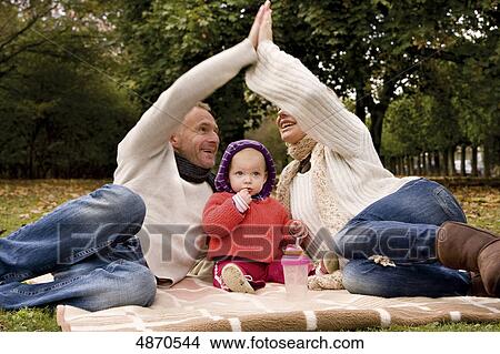 Picture - Family with toddler relaxing in park . Fotosearch