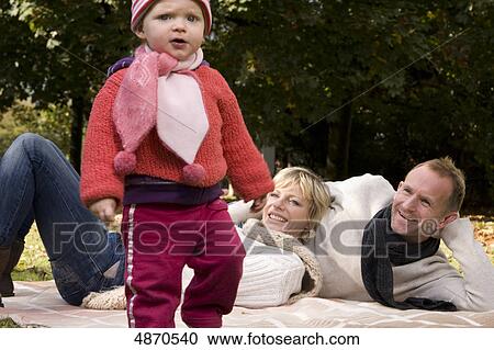 Family with toddler relaxing in park View Large Photo Image Stock Image - Family with toddler relaxing in park . Fotosearch