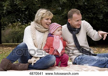 Family with toddler relaxing in park View Large Photo Image Stock Image - Family with toddler relaxing in park . Fotosearch