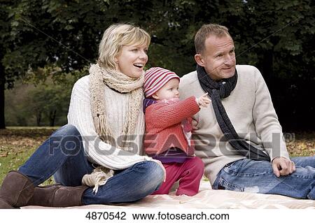 Family with toddler relaxing in park View Large Photo Image Stock Image - Family with toddler relaxing in park . Fotosearch