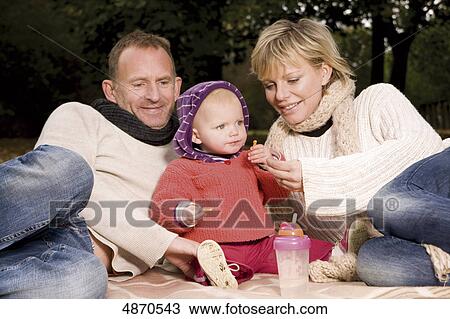 Family with toddler relaxing in park View Large Photo Image Stock Image - Family with toddler relaxing in park . Fotosearch